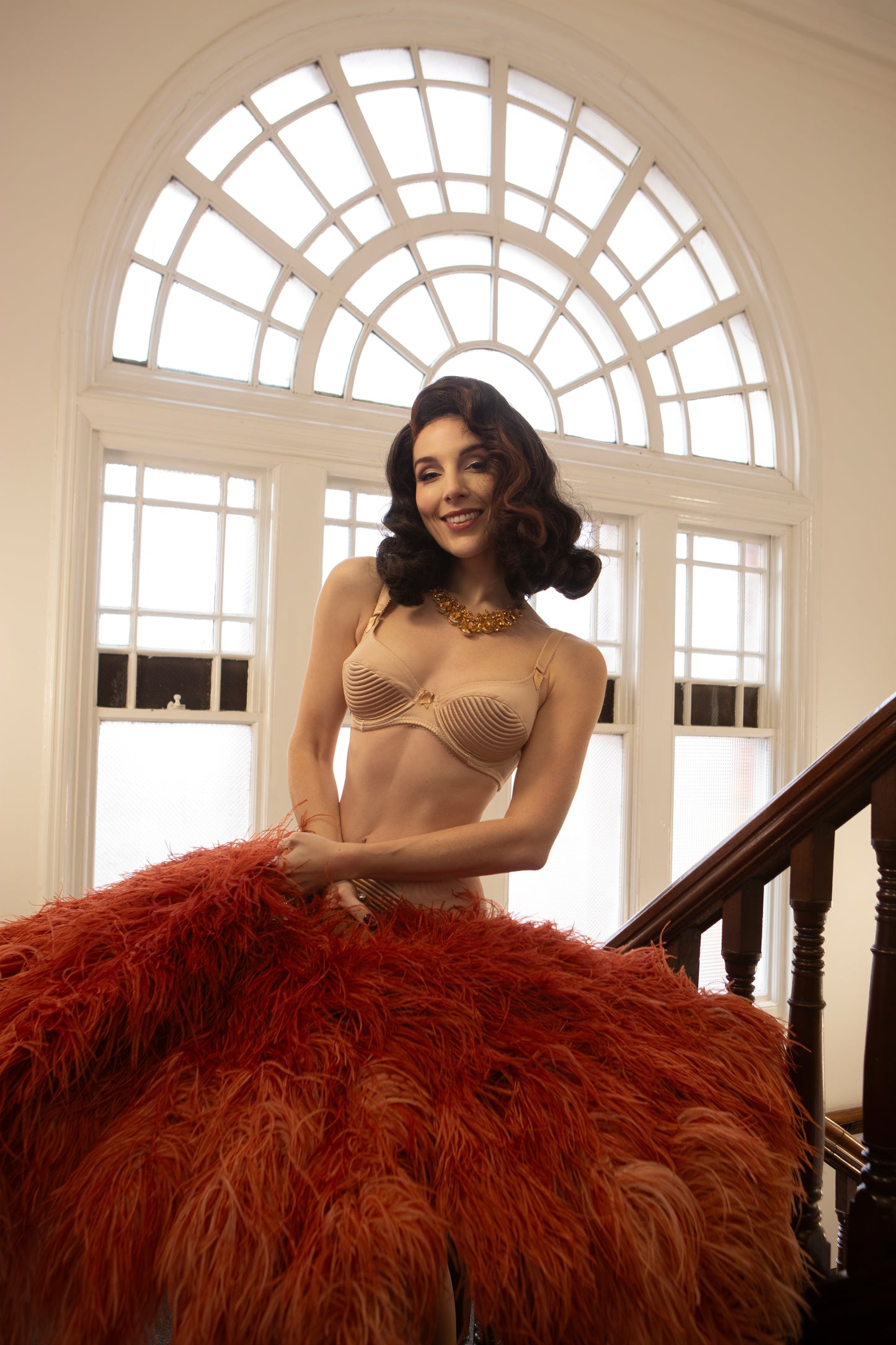 Nude beige satin underwired bra with vintage 1950s bullet bra inspired spiral stitching. Worn by a burlesque dancer, ideal showgirl lingerie costume. Bespoke lingerie made to measure in the UK