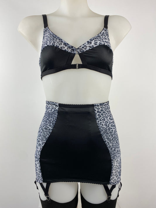 Front view of the Pip & Pantalaimon Monochrome Bralette with black satin lower cups and leopard mesh top cups and wings, featuring a vintage shape and front hook closure.