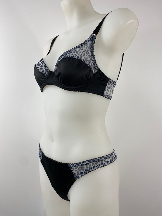 Model wearing the Pip & Pantalaimon Monochrome Thong with black satin front and seamless monochrome leopard mesh back, shown from behind to highlight smooth, no-seam finish.