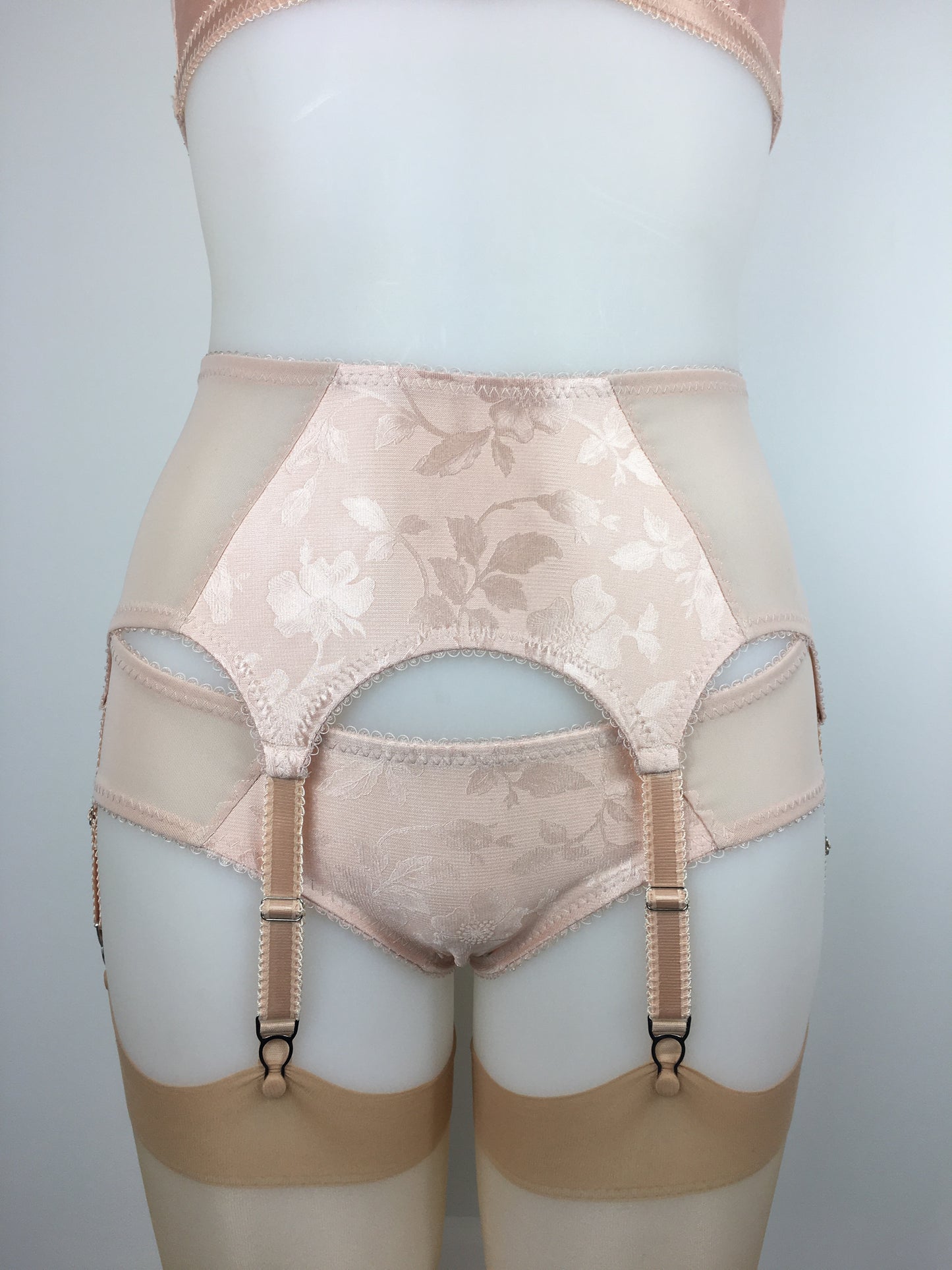 Our most authentic looking vintage inspired lingerie yet. Perfect peachy satin six strap suspender belt with a vintage peachy front panel and nude biscotti mesh sides. 6 adjustable suspender straps with a garter grip on each, perfect for holding your seamed stockings in place all day and for pairing with true vintage lingerie from 1920s, 1930s, 1940s and 1950s. Faux vintage lingerie