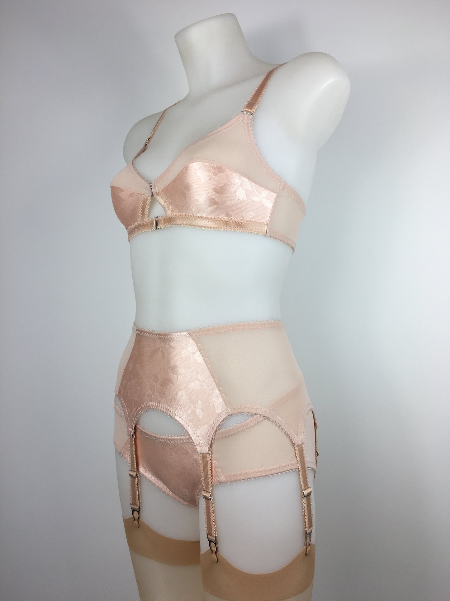 Our most authentic looking vintage inspired lingerie yet. Perfect peachy satin six strap suspender belt with a vintage peachy front panel and nude biscotti mesh sides. 6 adjustable suspender straps with a garter grip on each, perfect for holding your seamed stockings in place all day and for pairing with true vintage lingerie from 1920s, 1930s, 1940s and 1950s. Faux vintage lingerie