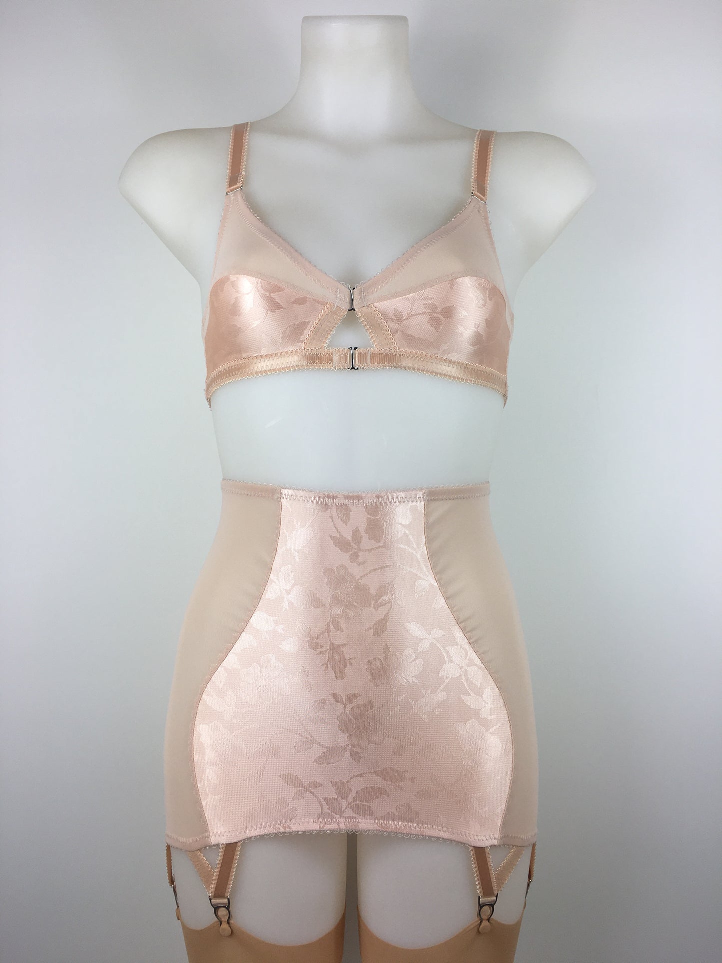 Our most authentic looking vintage inspired lingerie yet. Perfect peachy satin longline girdle with satin front and back panels. Keyhole back fastens with a steel hook after you've wiggled in. Perfect teamed with our faux vintage 1950s longline bra. The longline girdle has 6 metal suspender garter straps to keep your seamed stockings in place. Reproduction nude vintage lingerie made in the uk