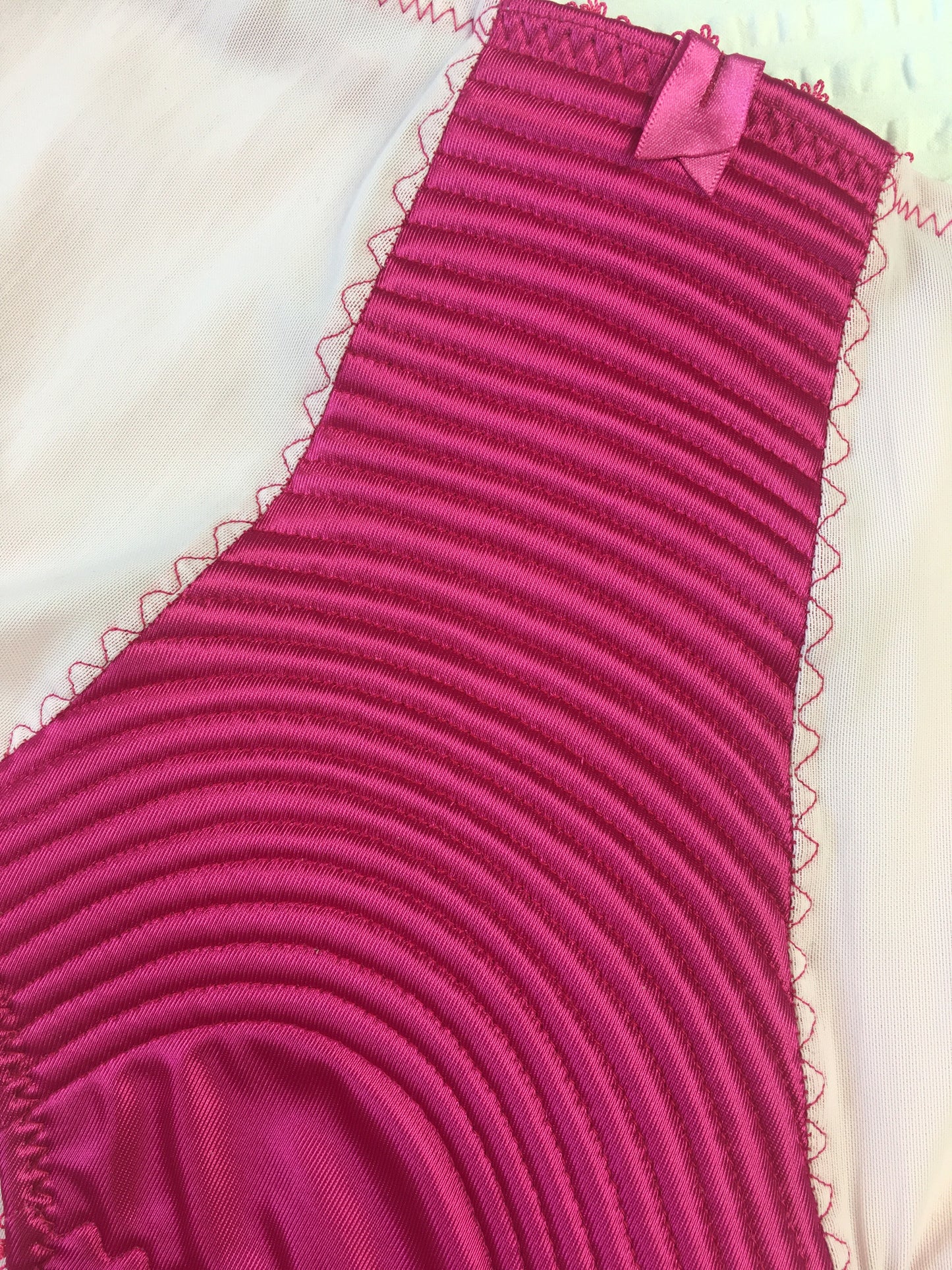 hot pink padded underwired bra with pale pink mesh and vintage style spiral stitching on the lower cup. Inspired by vintage 1950s bullet bras but with a softer modern shape. Matching 6 strap suspender belt with metal garter clips and high waisted pantie girdle knicker also available. Barbie vibe lingerie and underwear to be worn with seamed stockings