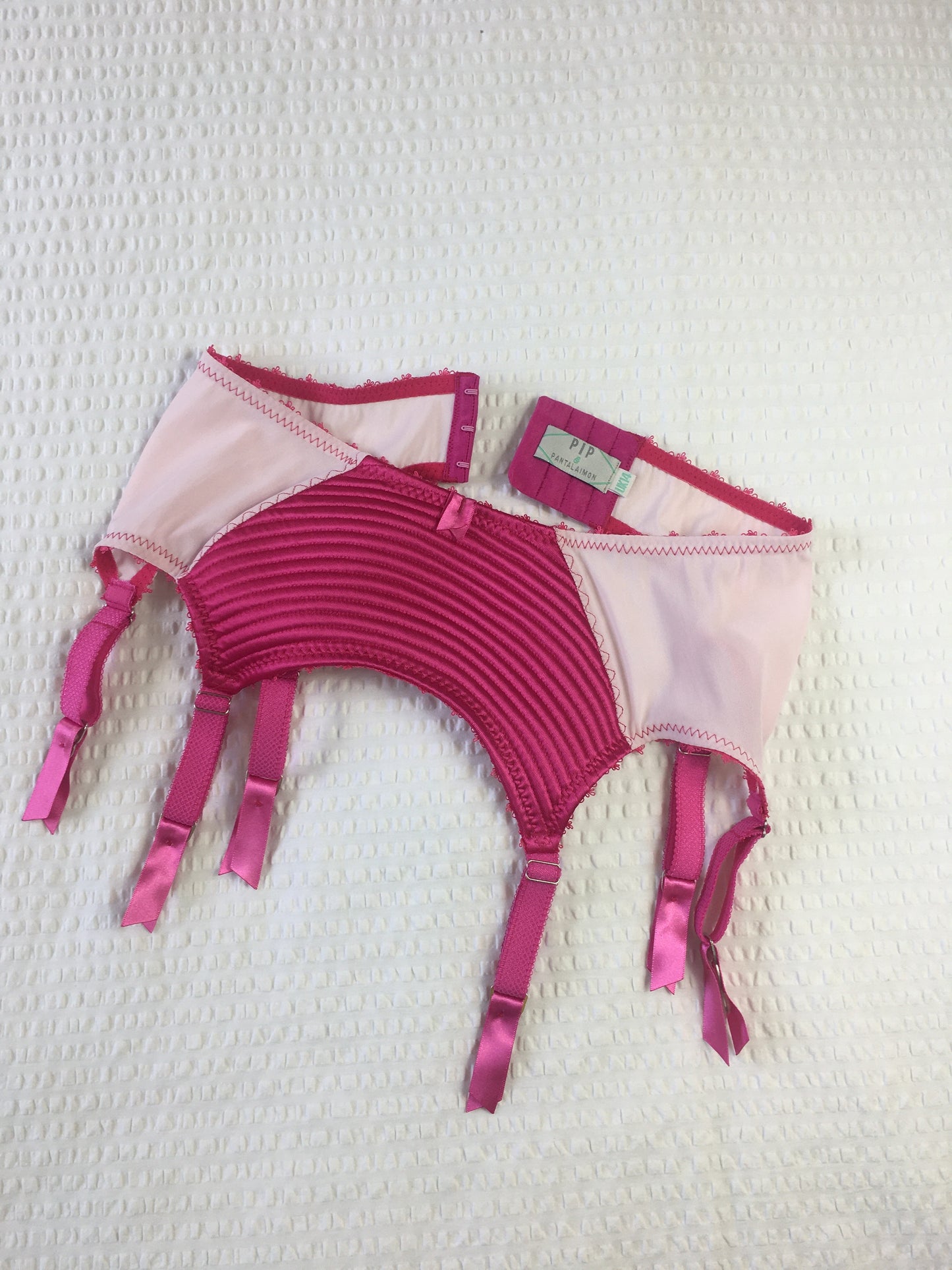 hot pink padded underwired bra with pale pink mesh and vintage style spiral stitching on the lower cup. Inspired by vintage 1950s bullet bras but with a softer modern shape. Matching 6 strap suspender belt with metal garter clips and high waisted pantie girdle knicker also available. Barbie vibe lingerie and underwear to be worn with seamed stockings