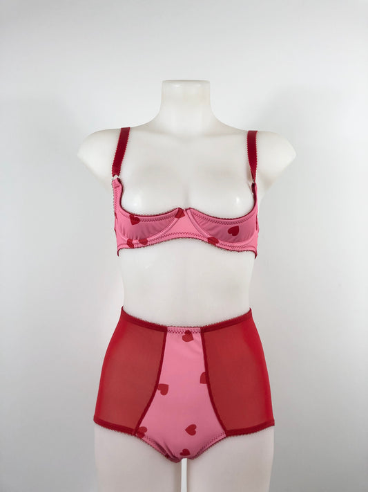 Red and pink lingerie set on a mannequin against a white background