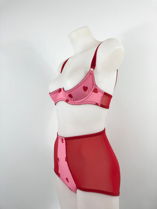Mannequin wearing a pink bra and red skirt on a white background