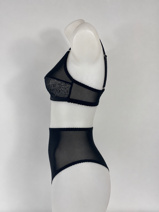 Black sheer mesh and lace lingerie set displayed on a white mannequin torso against a light gray studio background.