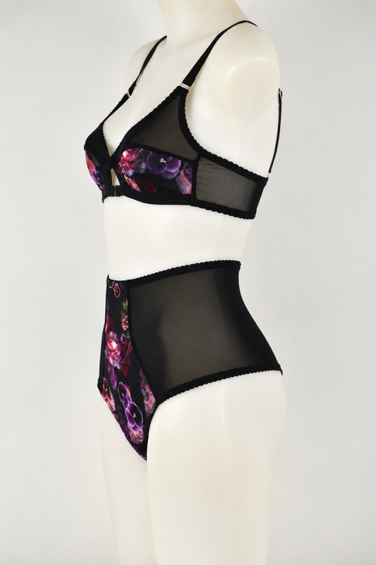Black lingerie set featuring a soft bralette that opens at the front, vintage 1950s inspired, with floral design on a mannequin against a white background