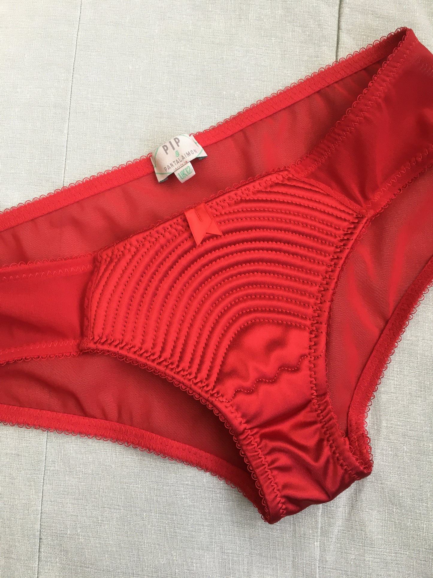 Spiral stitch lingerie 1950s bullet bra inspired underwear. reproduction foundations. Burlesque showgirl costume outfit spiral circle stitch six strap suspender belt, garter belt, underwired bra high waisted and classic cut panties knickers custom made in the UK in fabulous bright red satin.  1950s inspired fetish bettie page lingerie