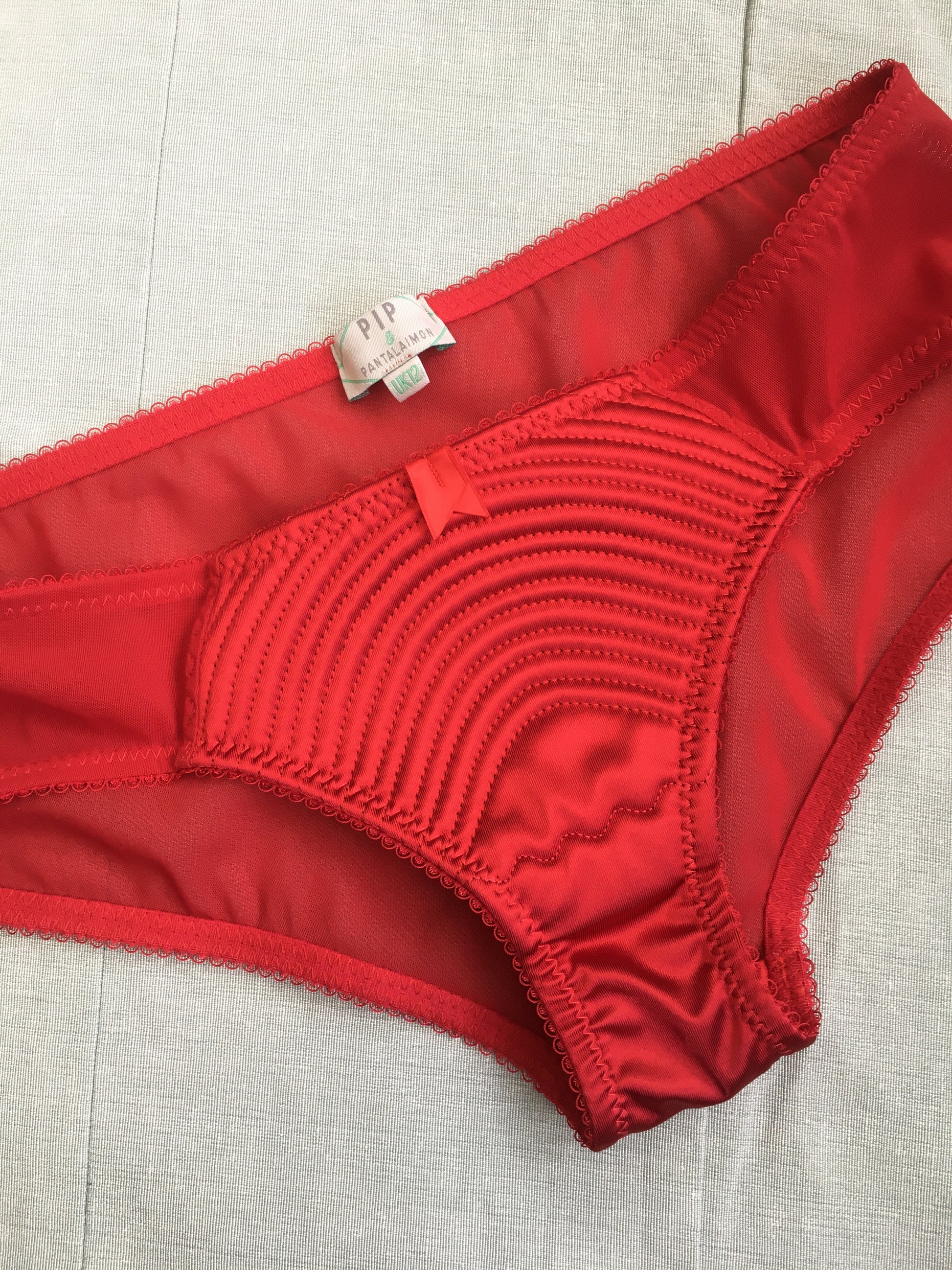 Spiral stitch lingerie 1950s bullet bra inspired underwear. reproduction foundations. Burlesque showgirl costume outfit spiral circle stitch six strap suspender belt, garter belt, underwired bra high waisted and classic cut panties knickers custom made in the UK in fabulous bright red satin.  1950s inspired fetish bettie page lingerie