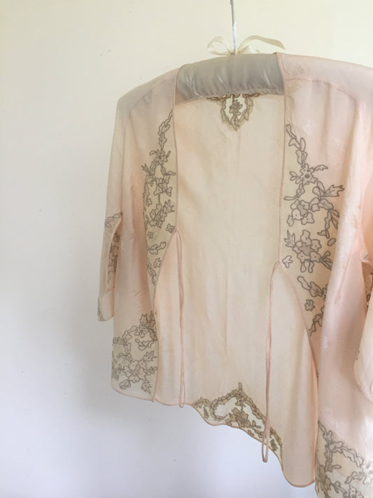 Our latest lovely vintage lingerie discovery, a peach 1940s jacquard woven silk bed jacket with drawn lace work and silk georgette and tulle embellishment appliqué.