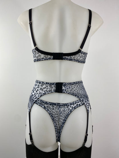 The Pip & Pantalaimon Monochrome Underwired Bra with black satin lower cups, sheer leopard mesh top cups, vintage-style projection, and dual fastening, shown from the front.