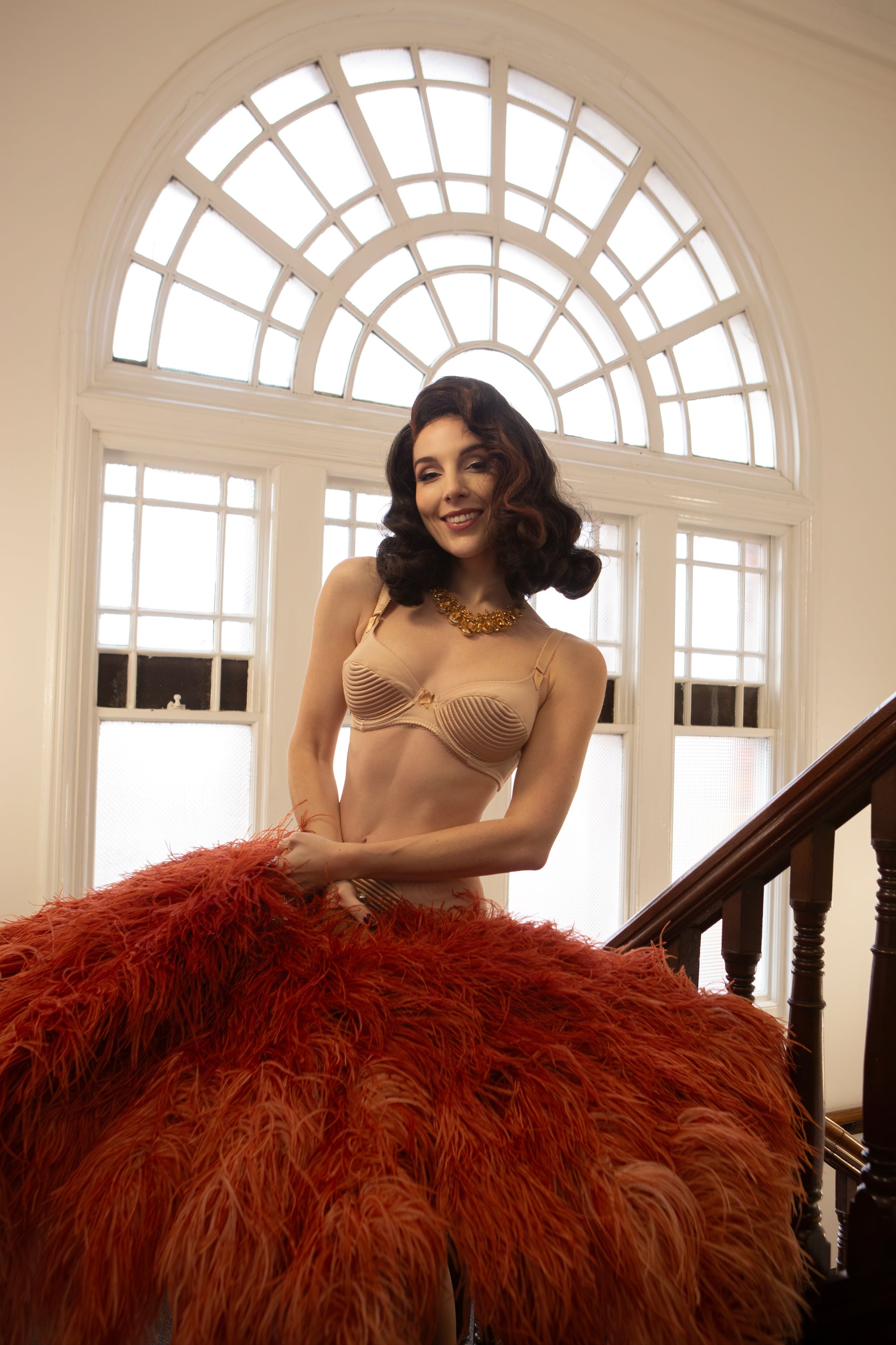 Nude beige satin underwired bra with vintage 1950s bullet bra inspired spiral stitching. Worn by a burlesque dancer, ideal showgirl lingerie costume. Bespoke lingerie made to measure in the UK 