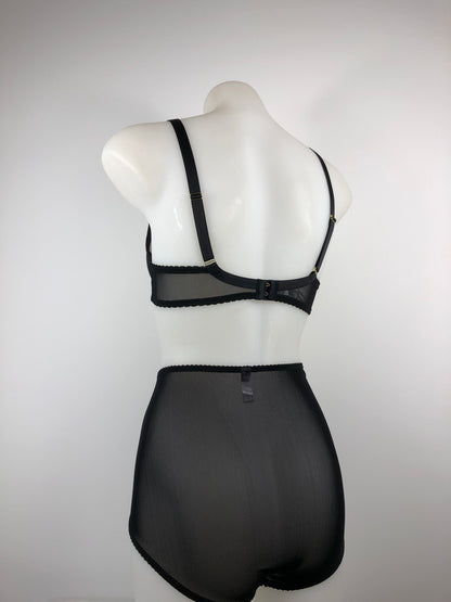 Black satin quarter cup bra with vintage bullet bra inspired spiral stitching. Worn by a burlesque dancer, ideal showgirl lingerie costume. Bespoke lingerie made to measure in the UK 