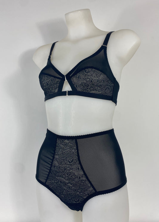 Black lace and sheer mesh lingerie set displayed on a white mannequin torso, featuring a bralette and high-waisted briefs against a plain light background.