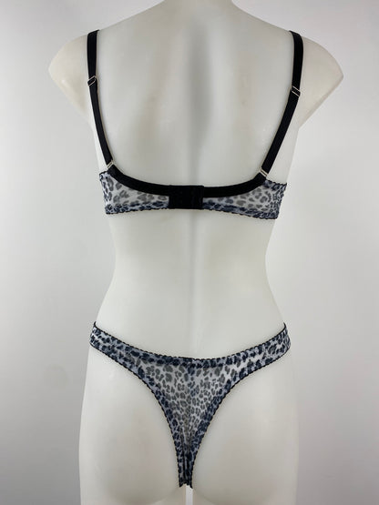 Model wearing the Pip & Pantalaimon Monochrome Thong with black satin front and seamless monochrome leopard mesh back, shown from behind to highlight smooth, no-seam finish.