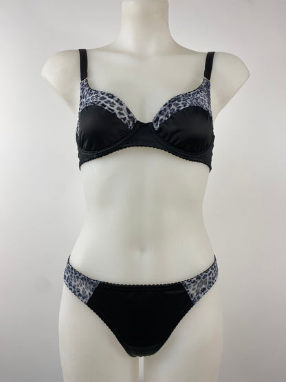 Model wearing the Pip & Pantalaimon Monochrome Thong with black satin front and seamless monochrome leopard mesh back, shown from behind to highlight smooth, no-seam finish.