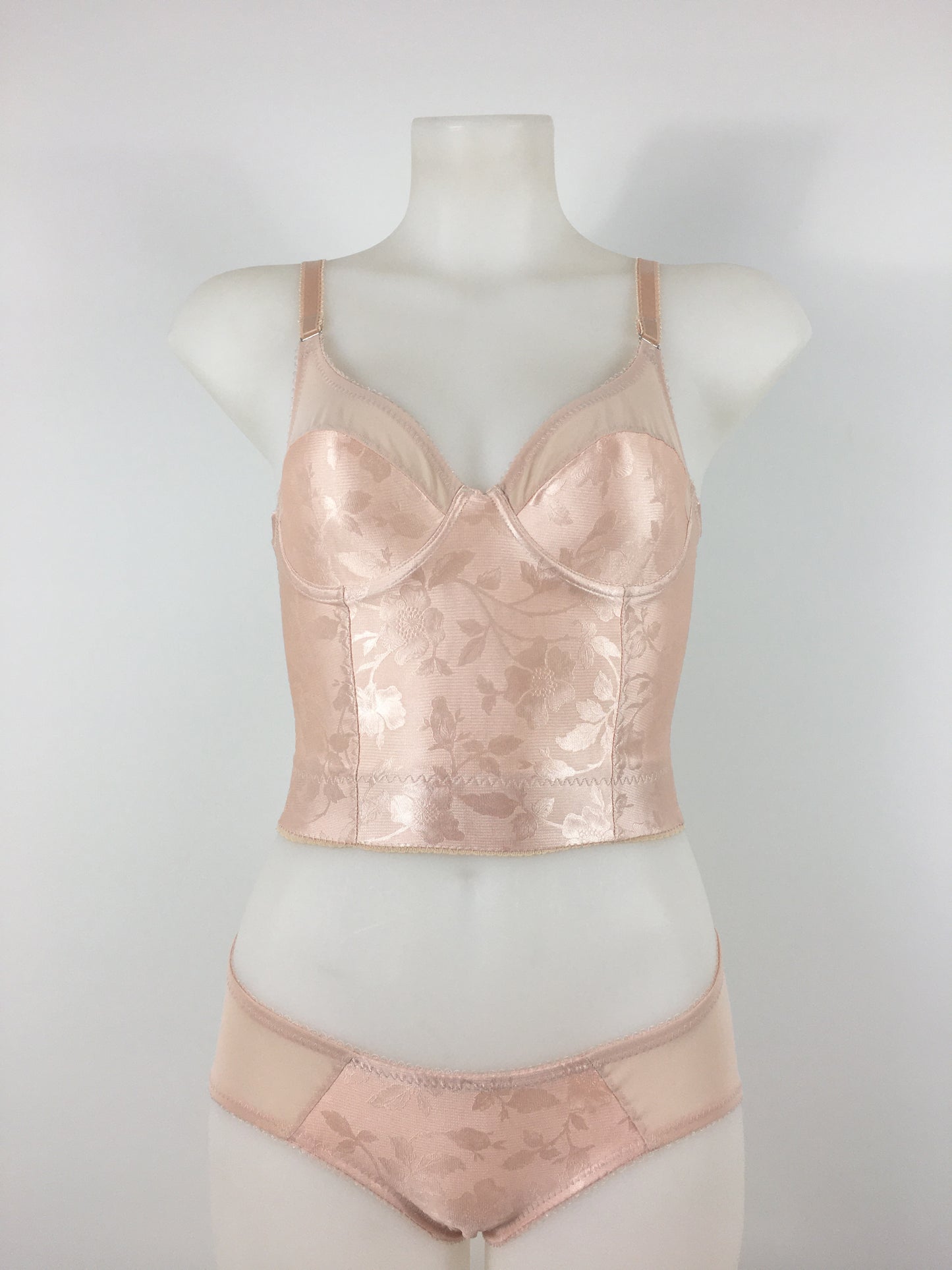 Our most authentic looking vintage inspired lingerie yet. Perfect peachy satin longline 1950s underwired bra. Peachy vintage front panels and nude biscotti mesh back. More subtle silhouette then a bullet bra, longline length makes this faux vintage bra perfect for wearing under true vintage dresses and fashion. Faux vintage reproduction lingerie made in the uk in a 1940s and 1950s underwear style