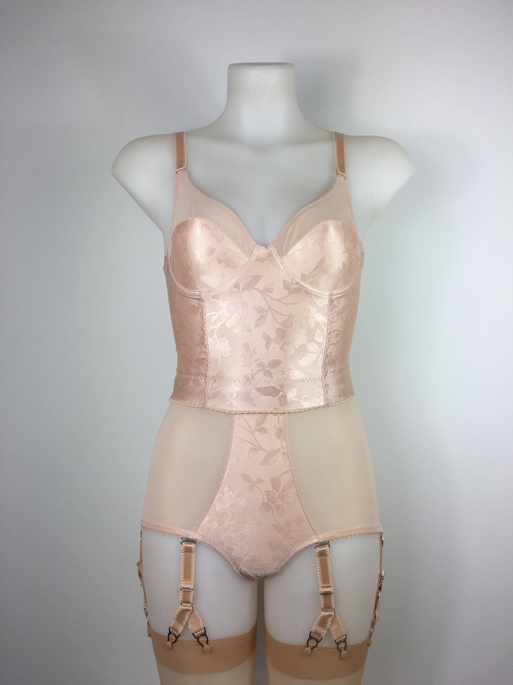 Our most authentic looking vintage inspired lingerie yet. Perfect peachy satin longline 1950s underwired bra. Peachy vintage front panels and nude biscotti mesh back. More subtle silhouette then a bullet bra, longline length makes this faux vintage bra perfect for wearing under true vintage dresses and fashion. Faux vintage reproduction lingerie made in the uk in a 1940s and 1950s underwear style