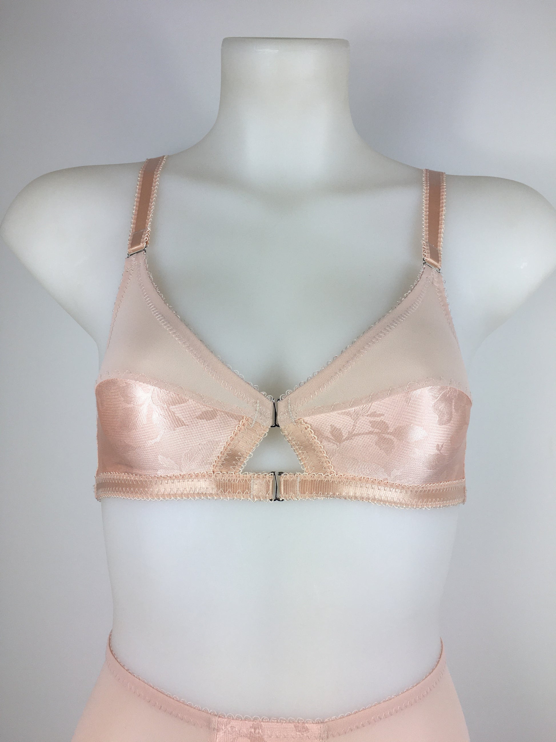 Our most authentic looking vintage inspired lingerie yet. Perfect peachy satin front fastening soft bra with faux vintage peach lower cups and nude biscotti mesh upper cups. Fastens at the front with two hooks. Our signature bralette shape makes the perfect faux 1950s 1940s bra. Not as pointed as a bullet bra, the bra gives a subtle vintage silhouette