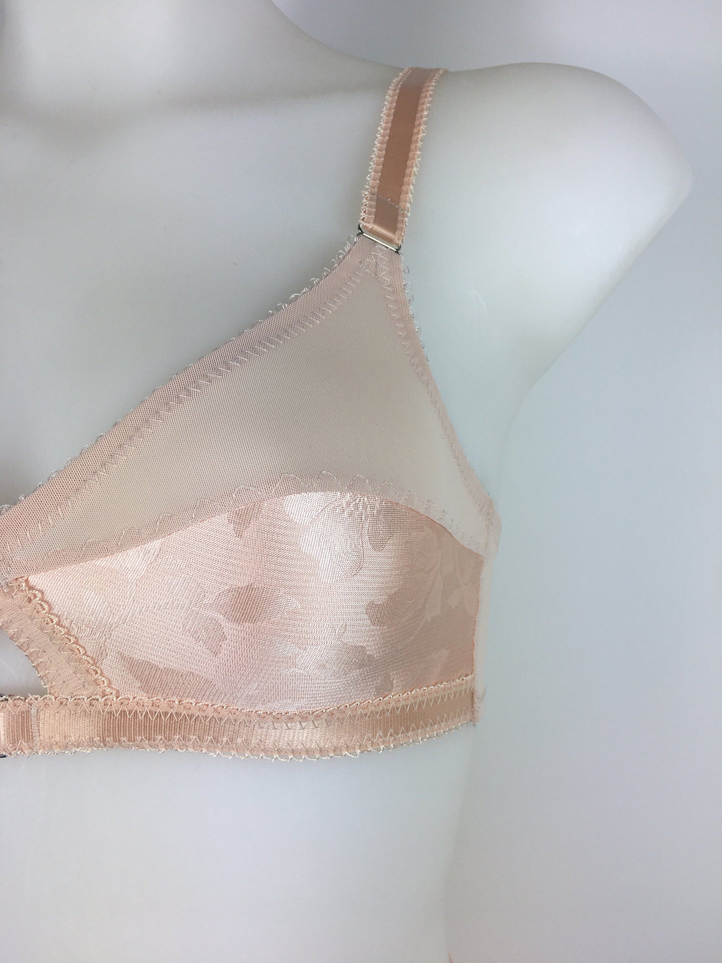 Our most authentic looking vintage inspired lingerie yet. Perfect peachy satin front fastening soft bra with faux vintage peach lower cups and nude biscotti mesh upper cups. Fastens at the front with two hooks. Our signature bralette shape makes the perfect faux 1950s 1940s bra. Not as pointed as a bullet bra, the bra gives a subtle vintage silhouette