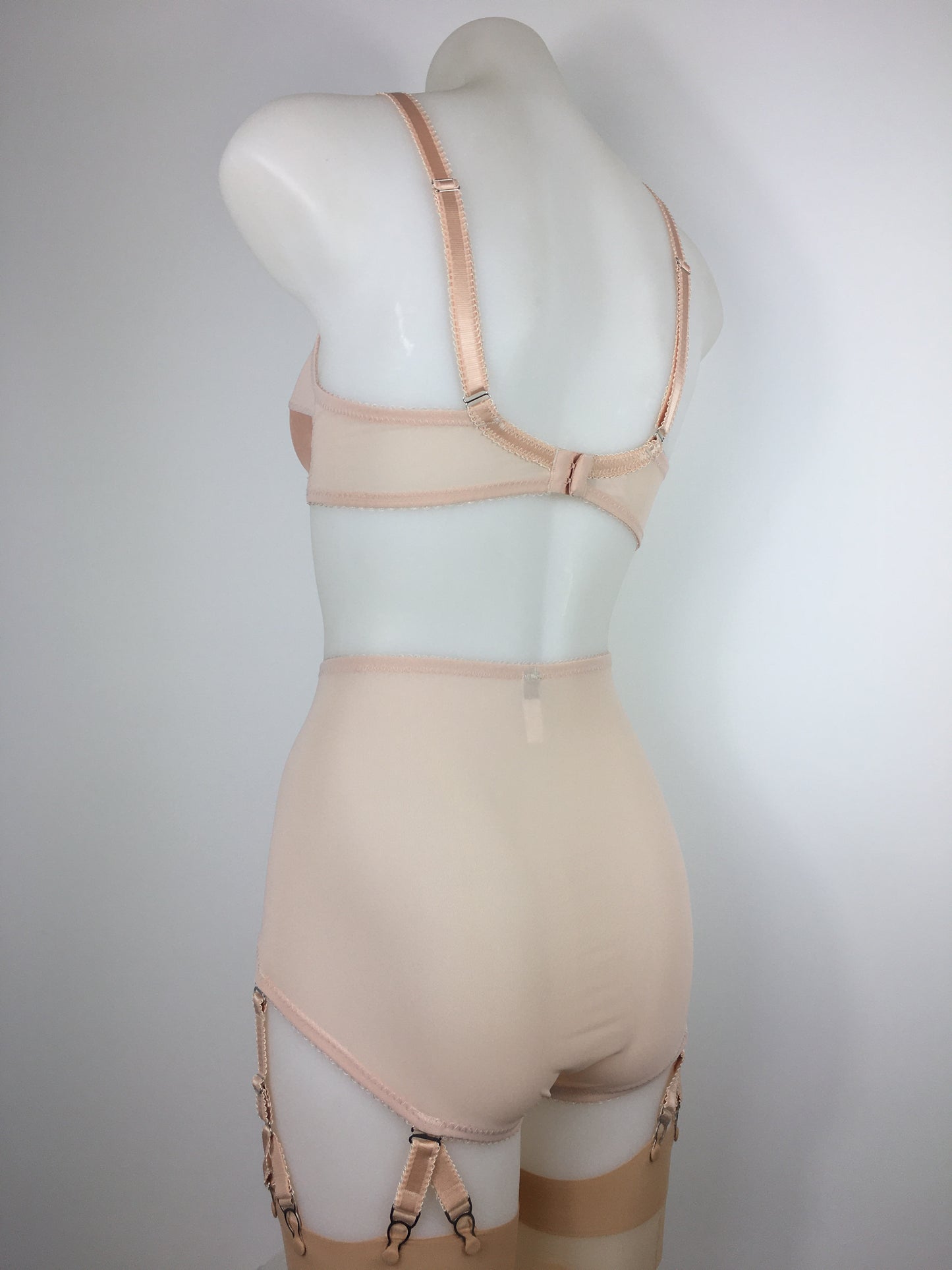 Our most authentic looking vintage inspired lingerie yet. Perfect peachy satin front fastening soft bra with faux vintage peach lower cups and nude biscotti mesh upper cups. Fastens at the front with two hooks. Our signature bralette shape makes the perfect faux 1950s 1940s bra. Not as pointed as a bullet bra, the bra gives a subtle vintage silhouette