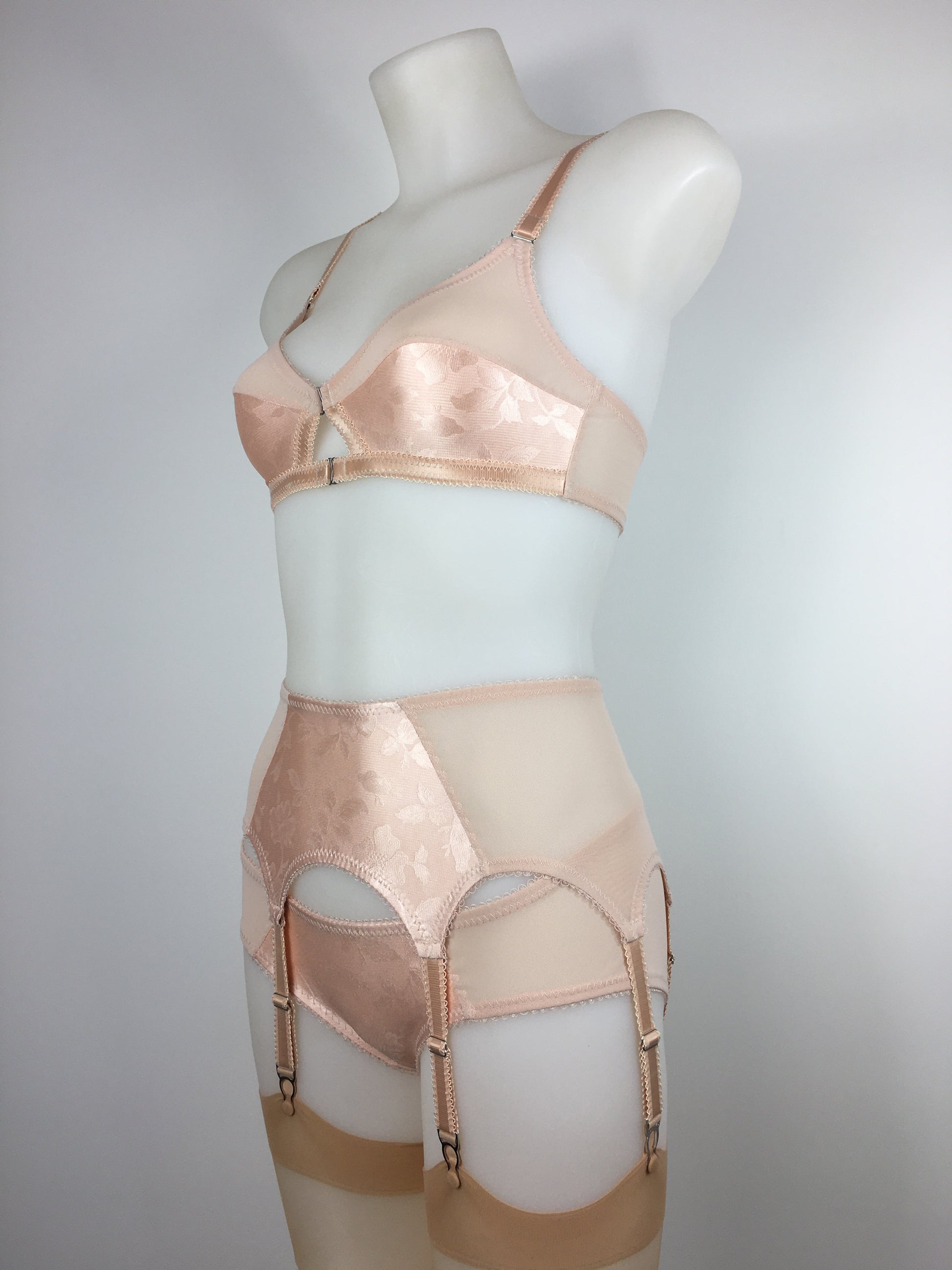 Our most authentic looking vintage inspired lingerie yet. Perfect peachy satin six strap suspender belt with a vintage peachy front panel and nude biscotti mesh sides. 6 adjustable suspender straps with a garter grip on each, perfect for holding your seamed stockings in place all day and for pairing with true vintage lingerie from 1920s, 1930s, 1940s and 1950s. Faux vintage lingerie