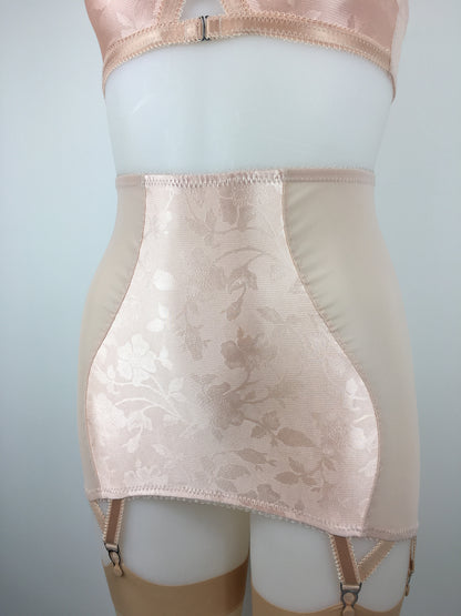 Our most authentic looking vintage inspired lingerie yet. Perfect peachy satin longline girdle with satin front and back panels. Keyhole back fastens with a steel hook after you've wiggled in. Perfect teamed with our faux vintage 1950s longline bra. The longline girdle has 6 metal suspender garter straps to keep your seamed stockings in place. Reproduction nude vintage lingerie made in the uk