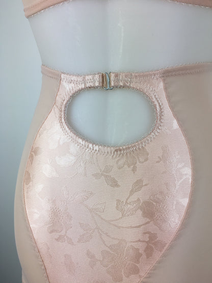 Our most authentic looking vintage inspired lingerie yet. Perfect peachy satin longline girdle with satin front and back panels. Keyhole back fastens with a steel hook after you've wiggled in. Perfect teamed with our faux vintage 1950s longline bra. The longline girdle has 6 metal suspender garter straps to keep your seamed stockings in place. Reproduction nude vintage lingerie made in the uk