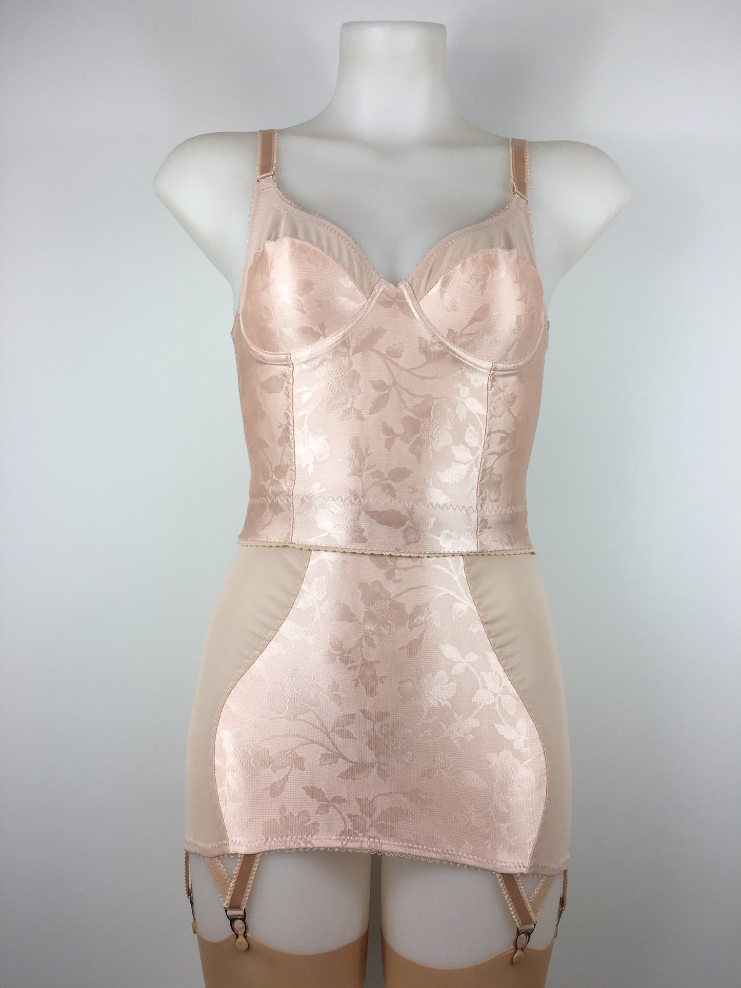 Our most authentic looking vintage inspired lingerie yet. Perfect peachy satin longline girdle with satin front and back panels. Keyhole back fastens with a steel hook after you've wiggled in. Perfect teamed with our faux vintage 1950s longline bra. The longline girdle has 6 metal suspender garter straps to keep your seamed stockings in place. Reproduction nude vintage lingerie made in the uk