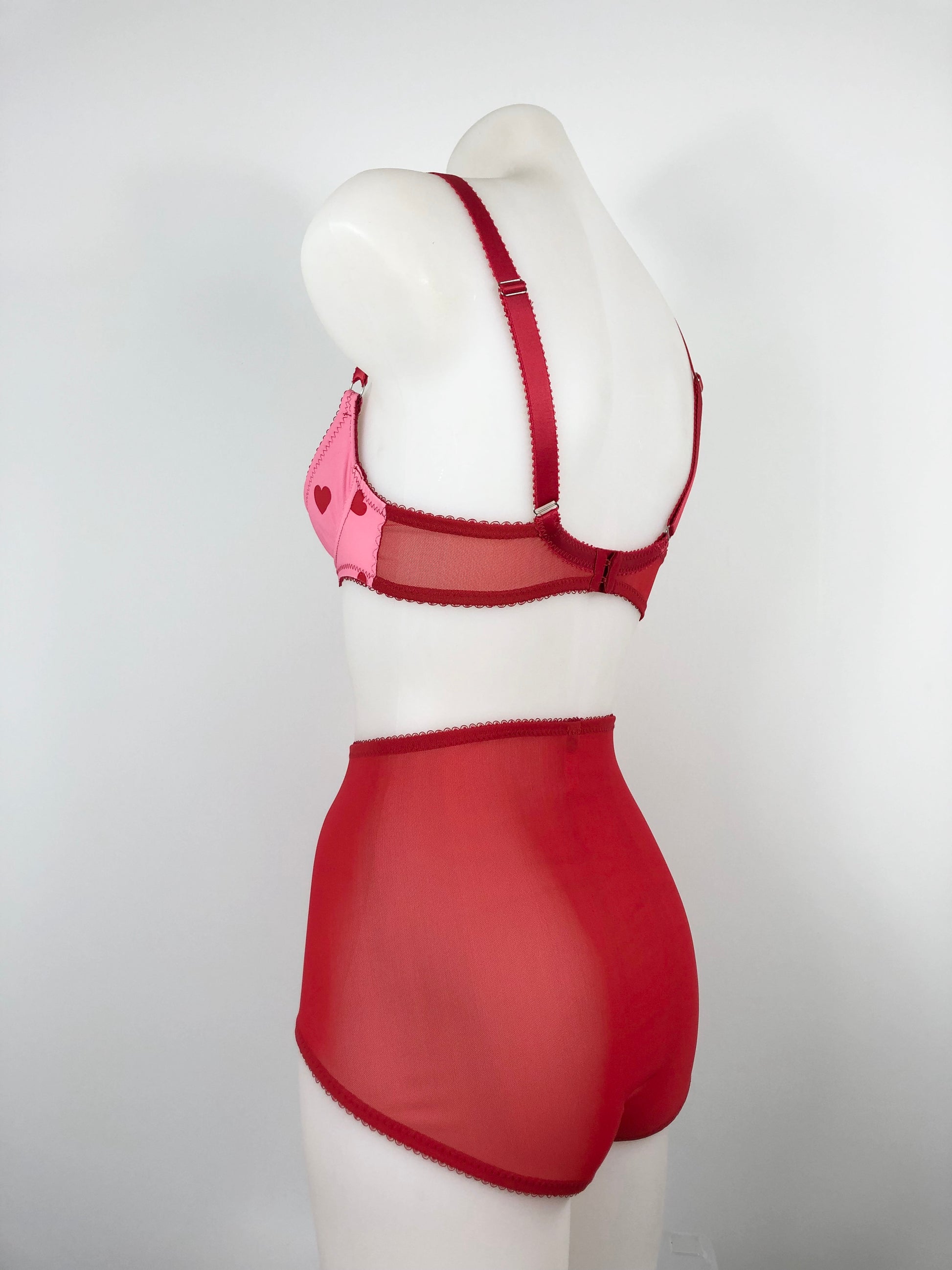 Red lingerie set on a mannequin against a white background