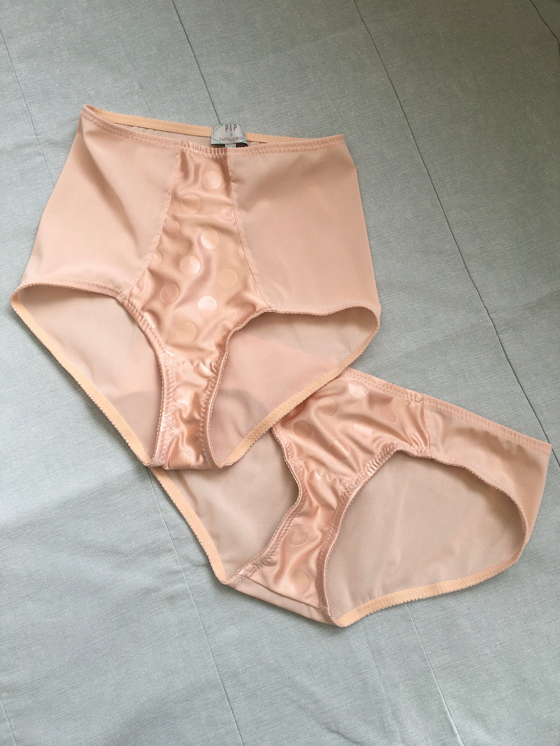 Vintage 1950s inspired shapewear lingerie underwear girdle girdlette longline 1940s suspender belt garter belt in muted vintage peach biscotti colour. Embodded large polka dot Goodwood pattern. Nude 1940s lingerie with six steel suspender clips for nylon seamed stockings, soft bra front fastening bralette and classic cut kickers or high waisted pantie girdles. Fetish bettie page style lingerie made in the UK by Pip and Pantalaimon