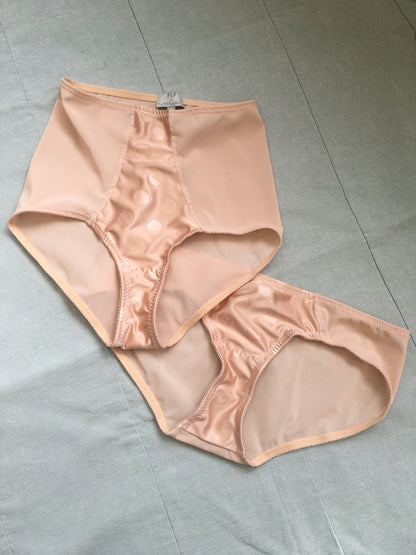 Vintage 1950s inspired shapewear lingerie underwear girdle girdlette longline 1940s suspender belt garter belt in muted vintage peach biscotti colour. Embodded large polka dot Goodwood pattern. Nude 1940s lingerie with six steel suspender clips for nylon seamed stockings, soft bra front fastening bralette and classic cut kickers or high waisted pantie girdles. Fetish bettie page style lingerie made in the UK by Pip and Pantalaimon