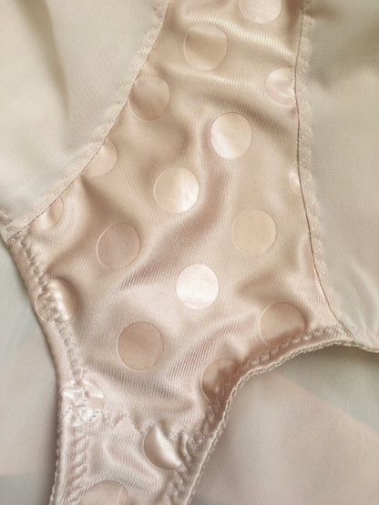 Vintage 1950s inspired shapewear lingerie underwear girdle girdlette longline 1940s suspender belt garter belt in muted vintage peach biscotti colour. Embodded large polka dot Goodwood pattern. Nude 1940s lingerie with six steel suspender clips for nylon seamed stockings, soft bra front fastening bralette and classic cut kickers or high waisted pantie girdles. Fetish bettie page style lingerie made in the UK by Pip and Pantalaimon