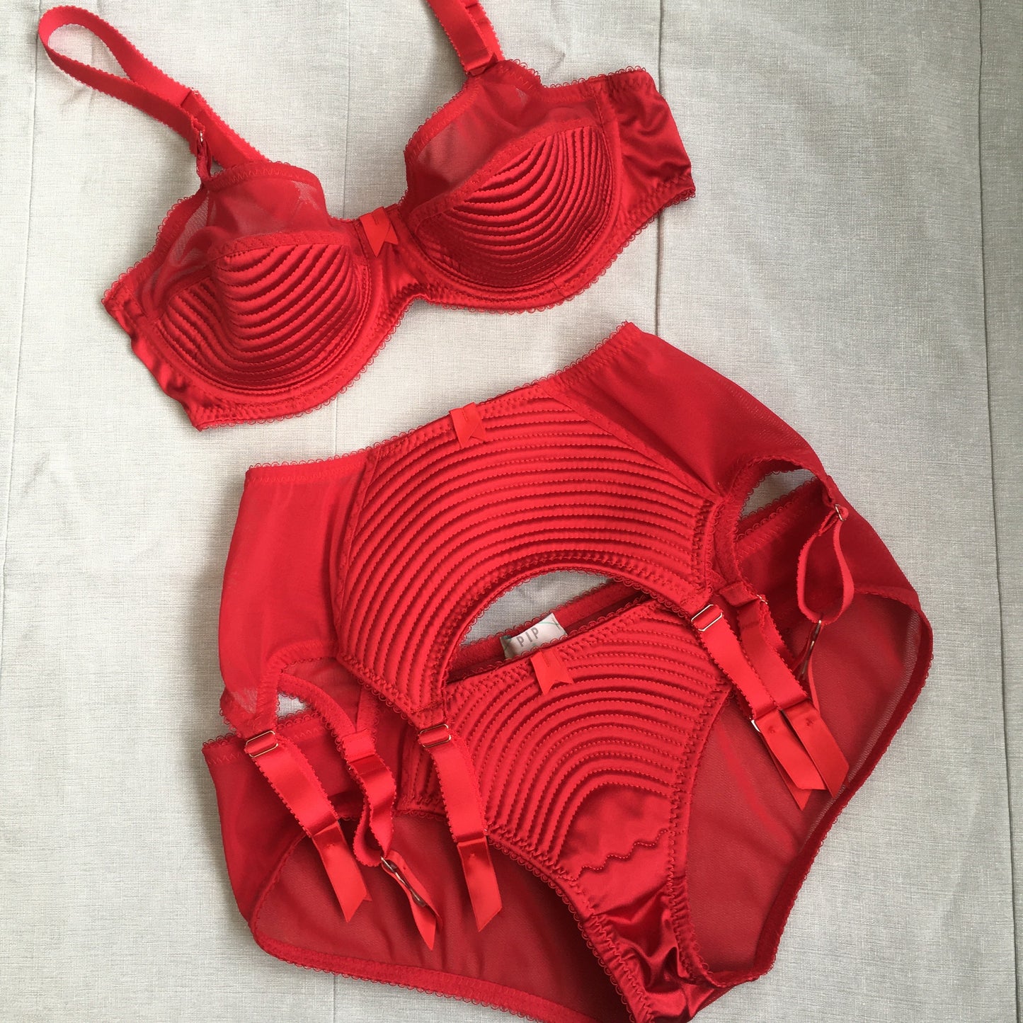 Spiral stitch lingerie 1950s bullet bra inspired underwear. reproduction foundations. Burlesque showgirl costume outfit spiral circle stitch six strap suspender belt, garter belt, underwired bra high waisted and classic cut panties knickers custom made in the UK in fabulous bright red satin.  1950s inspired fetish bettie page lingerie