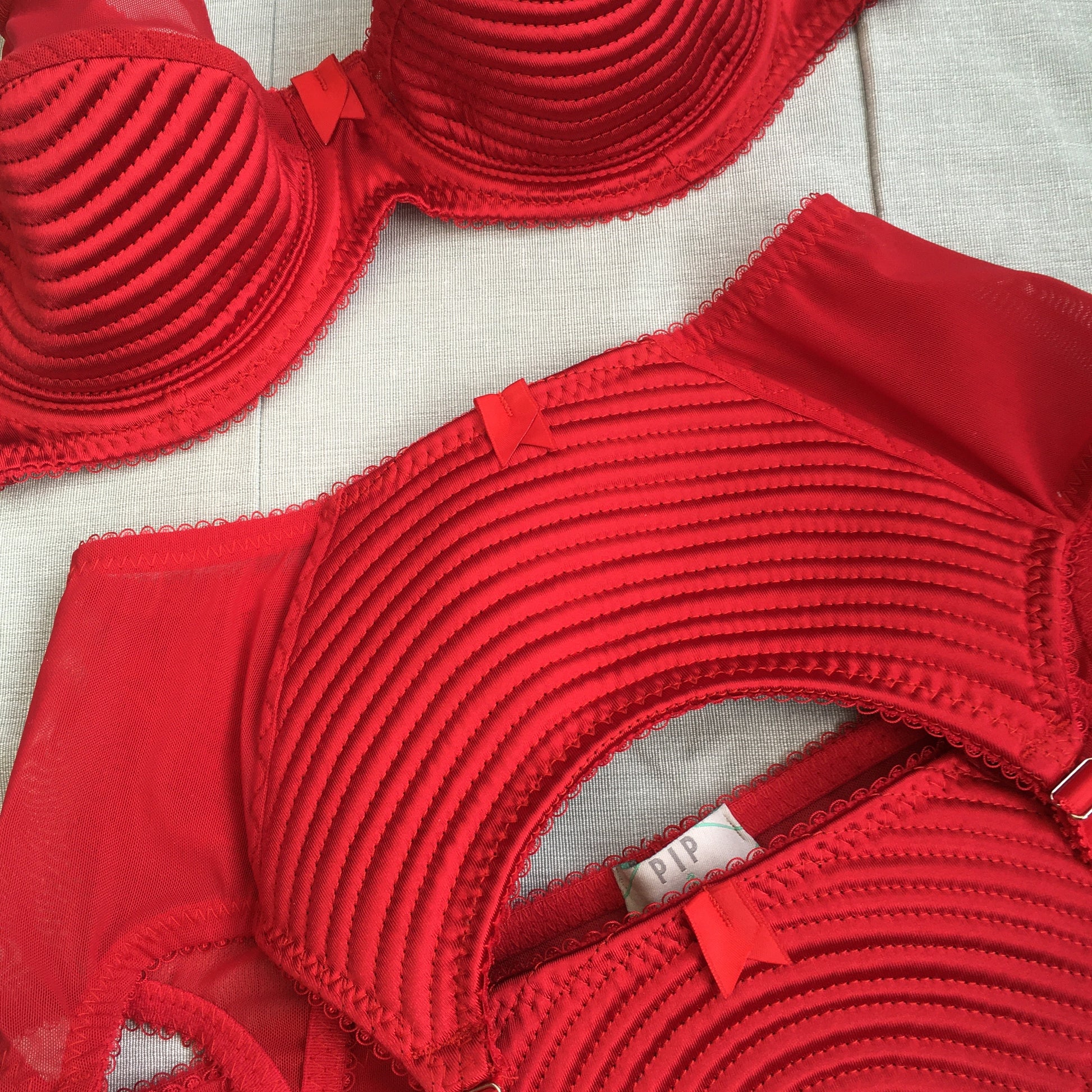 Spiral stitch lingerie 1950s bullet bra inspired underwear. reproduction foundations. Burlesque showgirl costume outfit spiral circle stitch six strap suspender belt, garter belt, underwired bra high waisted and classic cut panties knickers custom made in the UK in fabulous bright red satin.  1950s inspired fetish bettie page lingerie